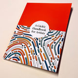 Book titled 'A Gicleé Handbook for Artists' with a red top cover and colorful abstract design on a beige background