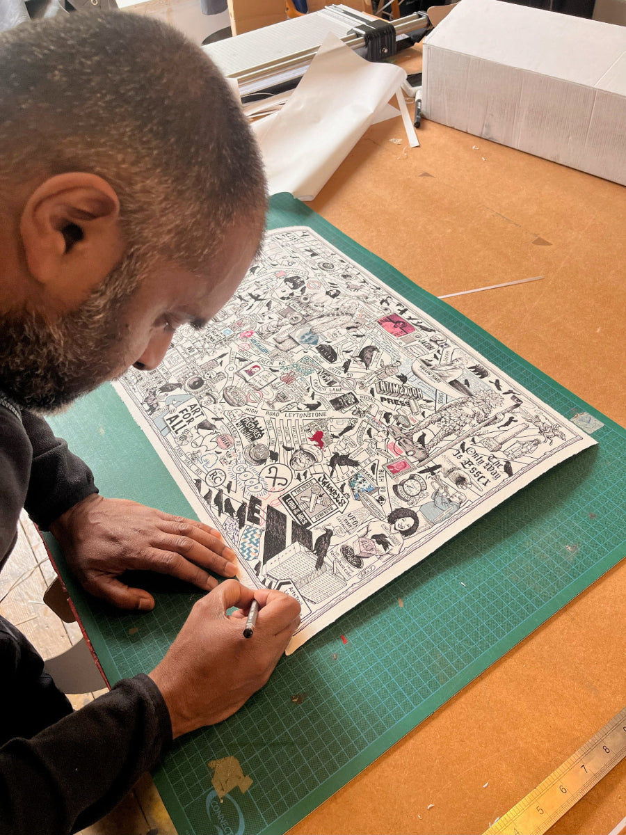 Person working on a detailed illustration on a green cutting mat with a ruler in the background.