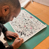 Person working on a detailed illustration on a green cutting mat with a ruler in the background.