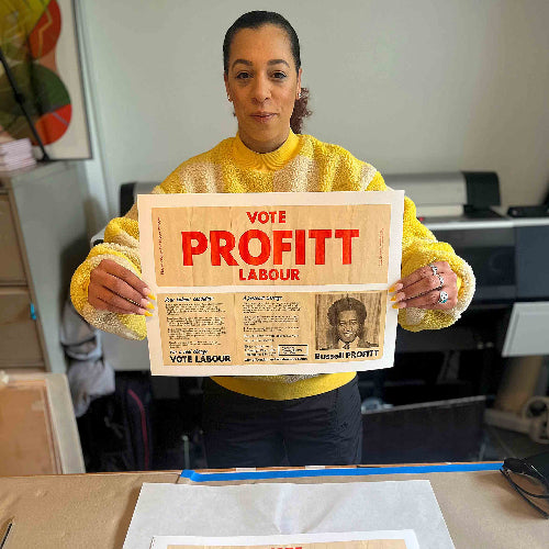 Person holding a sign with 'Vote Profitt Labour' in an indoor setting